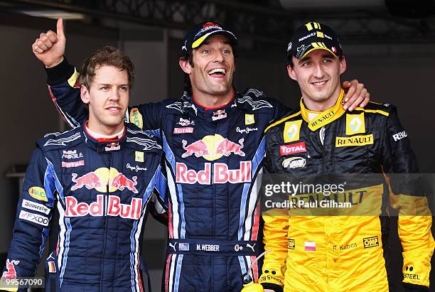 First placed Mark Webber of Australia and Red Bull Racing celebrates in parc ferme with second placed Robert Kubica of Poland and Renault and third...