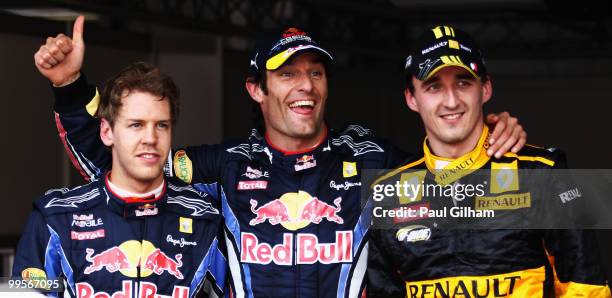 First placed Mark Webber of Australia and Red Bull Racing celebrates in parc ferme with second placed Robert Kubica of Poland and Renault and third...