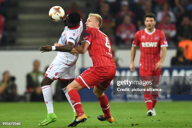 Belgrade's Richmond Boakye and Cologne's Frederik Soerensen vie for the ball during the Europa League match between 1.FC Cologne vs. Red Star...