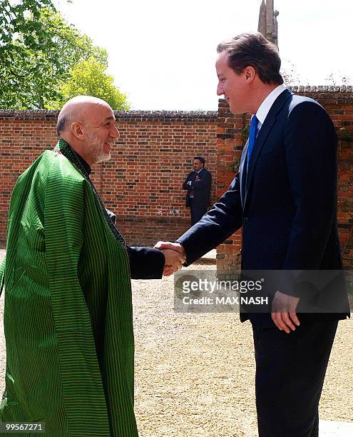 Britain's Prime Minister David Cameron shakes hands with Afganistan's President Hamid Karzai in the Prime Minister's country residence of Chequers,...