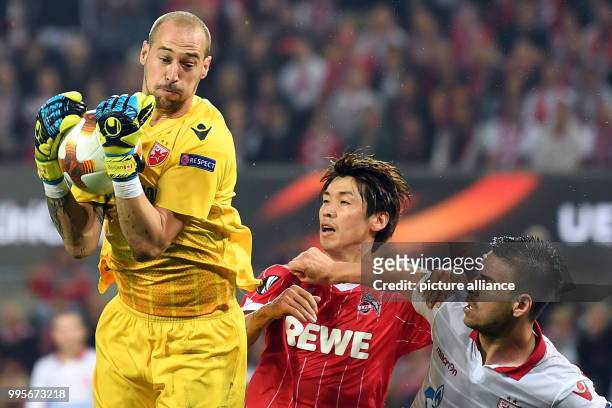 Belgrade's goalkeeper Milan Borjan and Cologne's Yuya Osako vie for the ball during the Europa League match between 1.FC Cologne vs. Red Star...