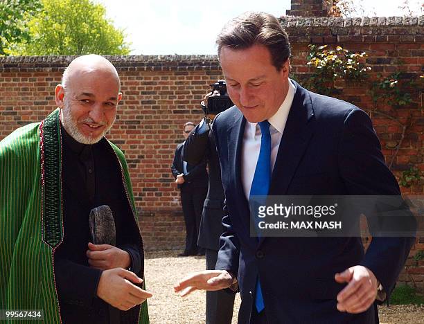 Britain's Prime Minister David Cameron greets Afganistan's President Hamid Karzai oh his arrival at the Prime Minister's country residence of...