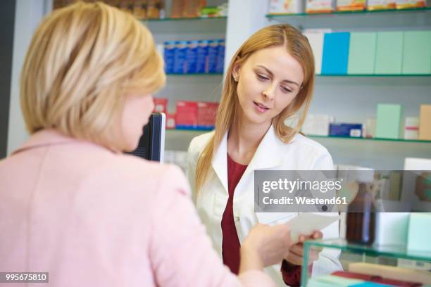 portrait of pharmacist advising woman in pharmacy - westend61 stockfoto's en -beelden