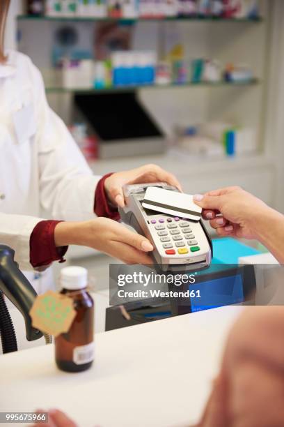 customer paying cashless with credit card in a pharmacy - westend61 stockfoto's en -beelden