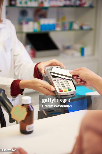 customer paying cashless with credit card in a pharmacy - nyckelkortläsare bildbanksfoton och bilder
