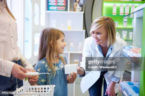 pharmacist advising mother and daughter in pharmacy - westend photos et images de collection