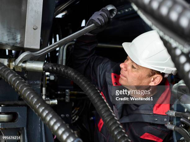 worker fixing hose line with screw wrench - westend photos et images de collection