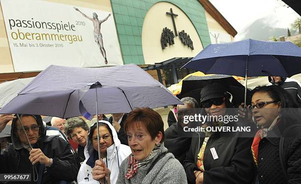 People shelter from the rain under umbrellas as they arrive for the premiere of Oberammergau's Passion Play on May 15, 2010. The Oberammergau Passion...