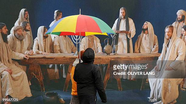 People shelter from the rain under umbrellas as they arrive for the premiere of Oberammergau's Passion Play on May 15, 2010. The Oberammergau Passion...