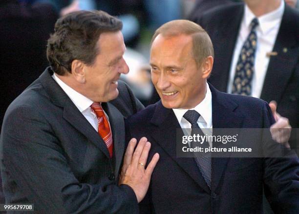 Former German Chancellor Gerhard Schroeder welcomes the Russian President Vladimir Putin at the Theater am Aegi in Hanover, Germany, 16 April 2004....
