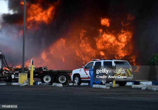 An out-of-control fire rages from a large pile of crushed vehicles near 5600 York St. July 10, 2018.