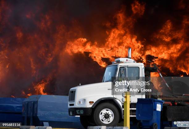 An out-of-control fire rages from a large pile of crushed vehicles near 5600 York St. July 10, 2018.