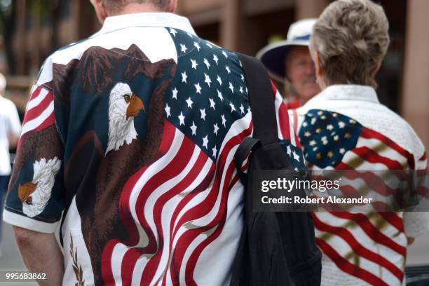 Man and woman wearing patriotic 'stars and stripes' shirts enjoy a Fourth of July holiday celebration in Santa Fe, New Mexico.