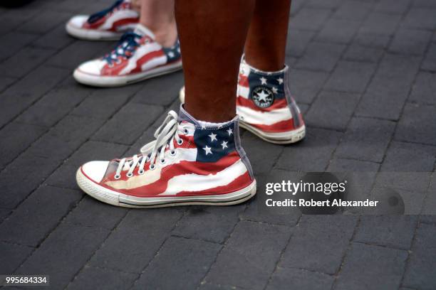 Man and woman wear 'stars and stripes' Converse Chuck Taylor All Star high top shoes as they enjoy a Fourth of July holiday celebration in Santa Fe,...