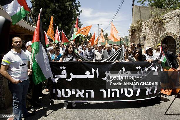 Palestinian and Arab Israeli protesters hold a banner with Arabic and Hebrew writing which reads, "No to Ethnic cleansing", during a demonstration...