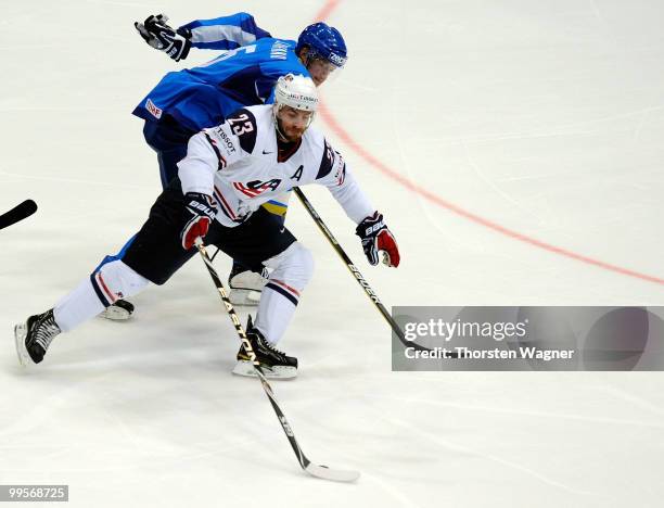 Eric Nystroem of United States battles for the puck with Alexei Litvinenko of Kazakhstan during the IIHF World Championship final round match between...