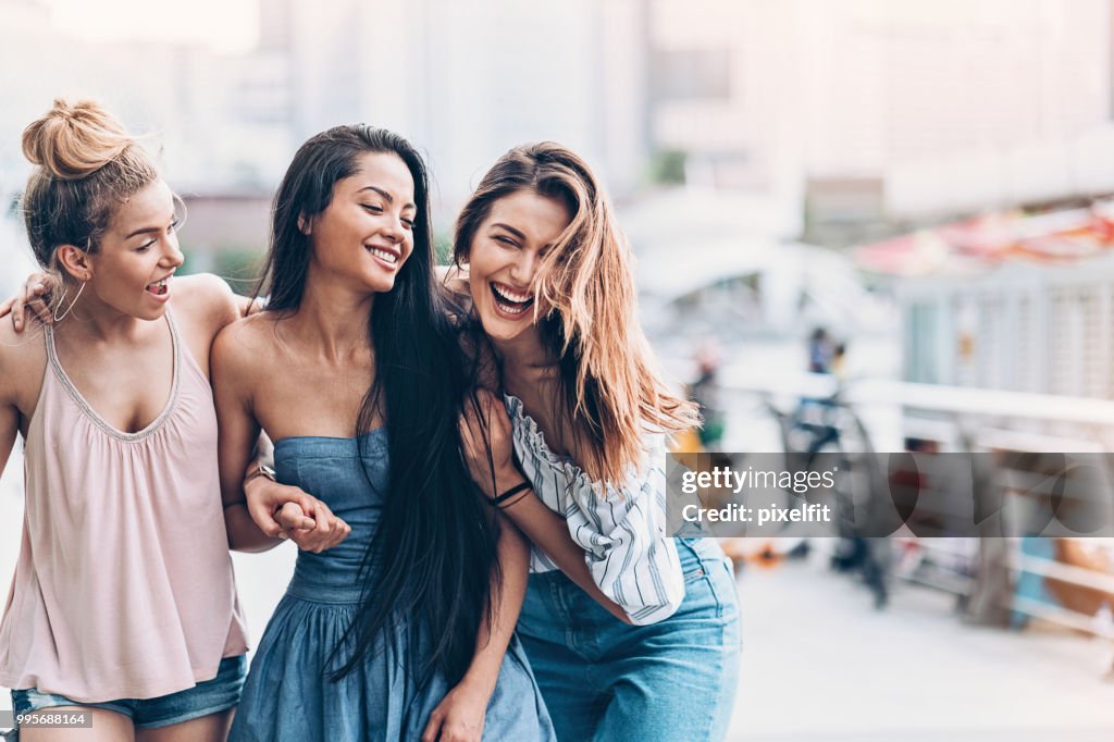 Drei junge Frauen gehen und lachen
