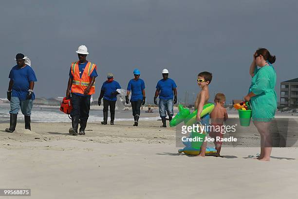 Logan Heyne Xander Heyne and Natasha Heyne wait for workers to pass by as they search the beach for tar balls to be picked up as they wash ashore...