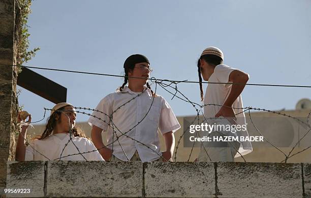 Jewish settler boy prepares to throw a stone at Palestinian and foreign peace activists protesting near an Israeli army checkpoint in the occupied...