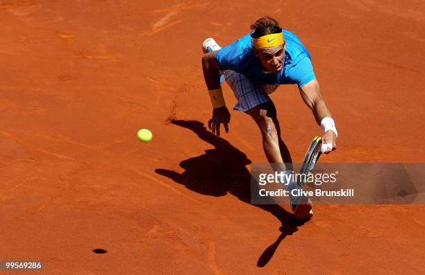 Rafael Nadal of Spain stretches to play a forehand against Nicolas Almagro of Spain in their semi final match during the Mutua Madrilena Madrid Open...