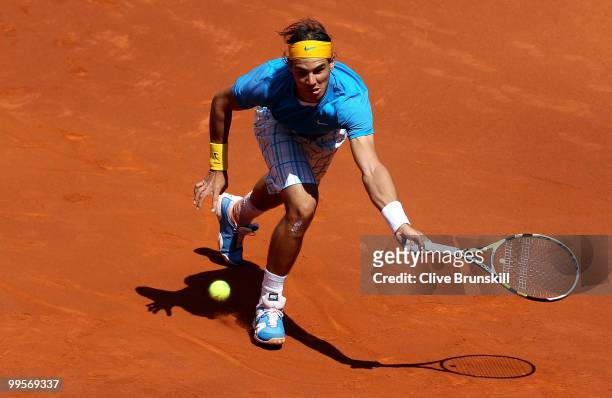 Rafael Nadal of Spain stretches to play a forehand against Nicolas Almagro of Spain in their semi final match during the Mutua Madrilena Madrid Open...