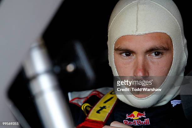 Scott Speed, driver of the Red Bull Toyota, sits in his car in the garage prior to practice for the NASCAR Sprint Cup Series Autism Speaks 400 at...