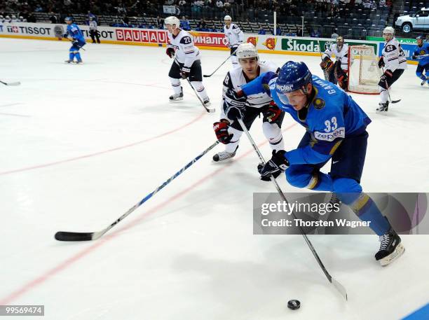 Jack Hillen of United States battles for the puck with Andrei Gavrilin of Kazakhstan during the IIHF World Championship final round match between USA...