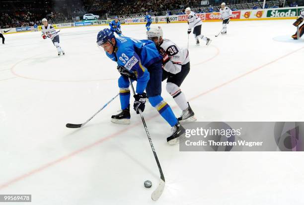 Jack Hillen of United States battles for the puck with Andrei Gavrilin of Kazakhstan during the IIHF World Championship final round match between USA...