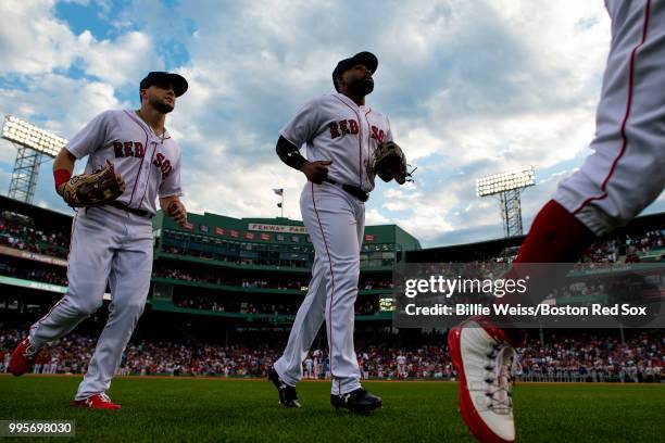 Andrew Benintendi, Jackie Bradley Jr. #19, and Mookie Betts of the Boston Red Sox run onto the field before a game against the Texas Rangers on July...