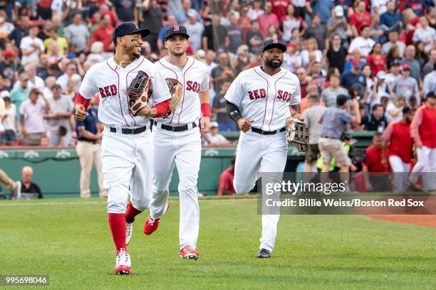 Andrew Benintendi, Jackie Bradley Jr. #19, and Mookie Betts of the Boston Red Sox run onto the field before a game against the Texas Rangers on July...