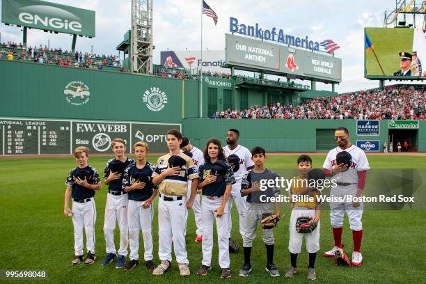 Little leaguers take the field with Andrew Benintendi, Jackie Bradley Jr. #19, and Mookie Betts of the Boston Red Sox run onto the field before a...