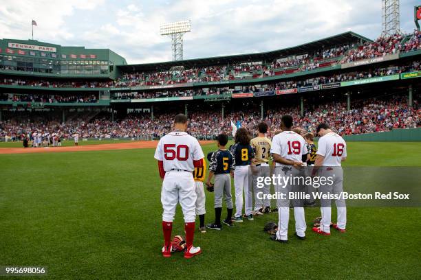 Little leaguers take the field with Andrew Benintendi, Jackie Bradley Jr. #19, and Mookie Betts of the Boston Red Sox run onto the field before a...