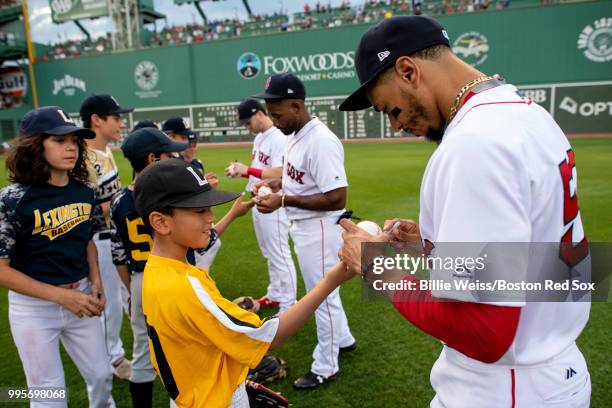 Little leaguers take the field with Andrew Benintendi, Jackie Bradley Jr. #19, and Mookie Betts of the Boston Red Sox run onto the field before a...