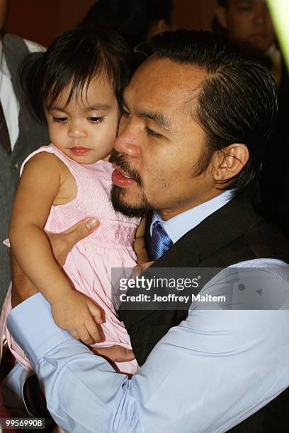 World welterweight boxing champion Manny Pacquiao carries his daughter Queen at the KCC Mall on May 15, 2010 in General Santos, Philippines. Pacquiao...
