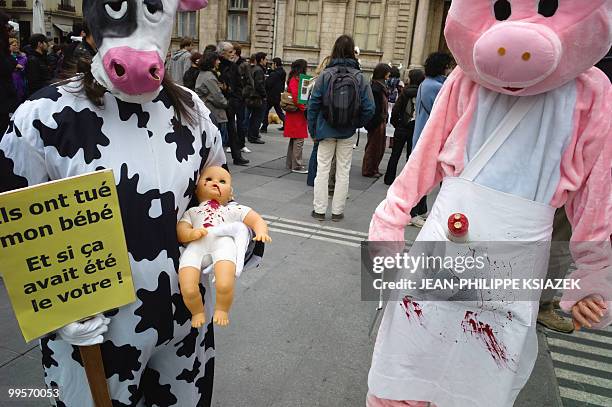 People disguised as a cow holding a bloody baby doll and as a pig take part in a rally of Vegetarian activists during the "Veggie pride"...