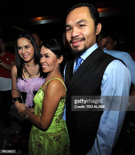 Philippine boxing superstar Manny Pacquiao poses for a photo with his mother Dionesia and wife Jinkee during his victory party after winning a seat...