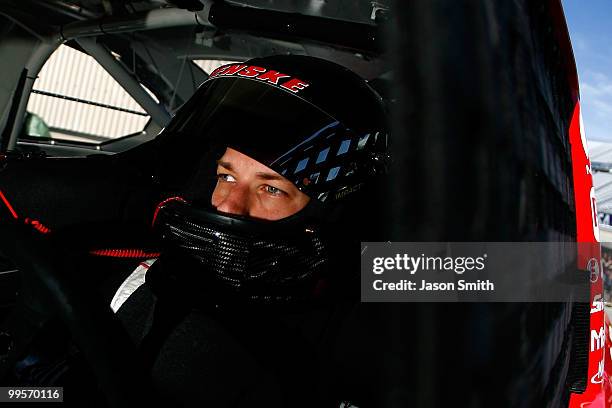 Brad Keselowski, driver of the Penske Dodge Dodge, sits in his car in the garage during practice for the NASCAR Sprint Cup Series Autism Speaks 400...