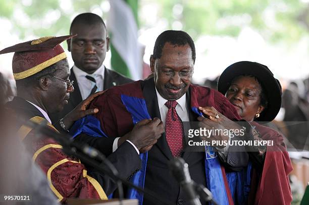 Nigerian former Chief of Justice, Mohammed Uwais puts on an academic gawn to earn a doctoral degree as Nigerian President Goodluck Jonathan attends...