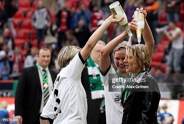 Head coach Martina Voss-Tecklenburg of Duisburg is showered with champaign by Alexandra Popp and Anne van Bonn after winning the DFB Women's Cup...