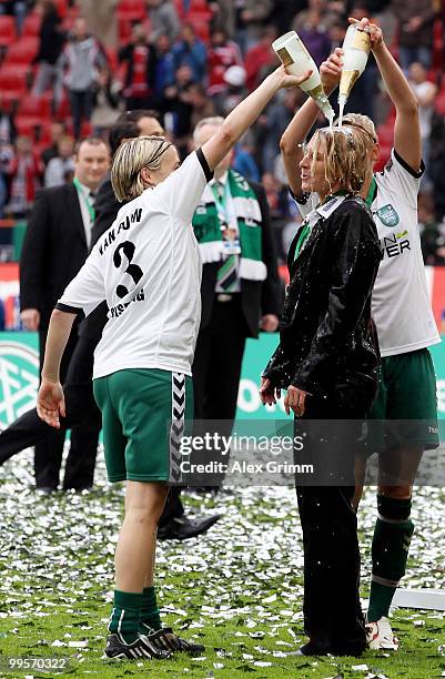 Head coach Martina Voss-Tecklenburg of Duisburg is showered with champaign by Alexandra Popp and Anne van Bonn after winning the DFB Women's Cup...