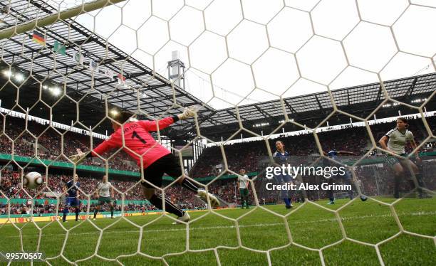 Annike Krahn of Duisburg scores her team's first goal against goalkeeper Jana Burmeister of Jena during the DFB Women's Cup final match between FCR...