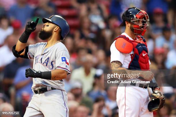 Rougned Odor of the Texas Rangers crosses home plate on his solo home run as catcher Blake Swihart of the Boston Red Sox looks on in the second...