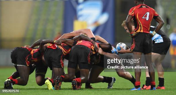 Four players from each team in a scrum during the Oktoberfest 7s international rugby match between Germany and Uganda at the Olympic Stadium in...