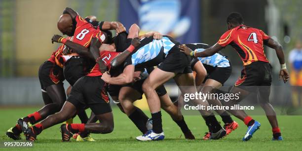 Four players from each team in a scrum during the Oktoberfest 7s international rugby match between Germany and Uganda at the Olympic Stadium in...