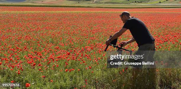 Man prepares to take a photo during Annual Blossom in Castelluccio on July 10, 2018 in Castelluccio di Norcia near Perugia, Italy.