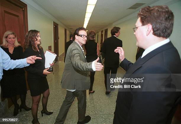 Bono of U2 greets Capitol Hill staffers as he leaves a meeting on third world debt relief with Sen. Rod Grams and Rep. John Kasich .