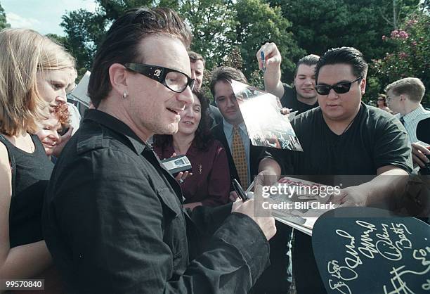 Bono of U2 is mobbed by fans seeking autographs following a press conference on third world debt relief at the US Capitol.