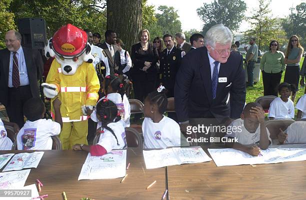 Sen Edward Kennedy along with Sparky watch over school kids as they draw Saprky in coloring books at the press conference to kick off fire prevention...