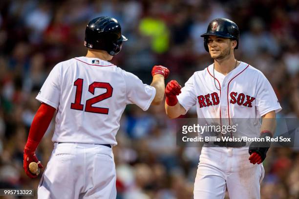 Andrew Benintendi of the Boston Red Sox reacts with Brock Holt after scoring during the third inning of a game against the Texas Rangers on July 10,...