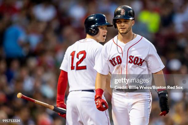 Andrew Benintendi of the Boston Red Sox reacts with Brock Holt after scoring during the third inning of a game against the Texas Rangers on July 10,...